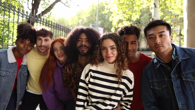 Happy playful multiethnic group of young friends standing together outdoors - multiracial millennial students meeting in the city, concepts of youth, 