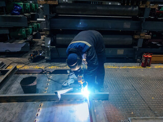 Obraz premium Factory worker in protective mask welding iron parts, close up