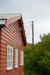 Power lines connected to red wooden barracks.