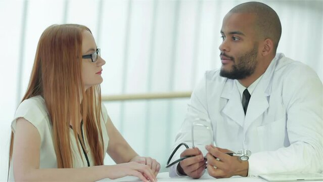 Doctor talking with the patient while sitting at a table in the hospital