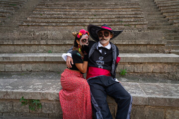 Young couple dressed up as catrines in a quirky pose