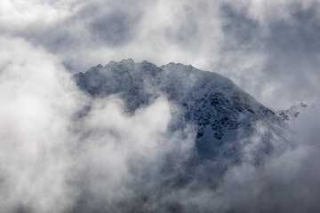 Mountain peak emerge through the misty clouds at swiss alps near Davos, Switzerland