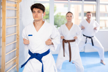 Kata karate teacher conducts classes and performs movements and fighting techniques together with students to prepare them for competitions.