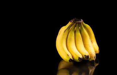 Bananas, a beautiful composition with bananas on a reflective surface with a dark background, selective focus.