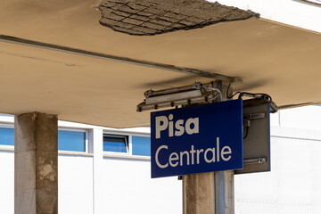 Sign in Pisa central train station and broken concrete roof because of neglected maintenance