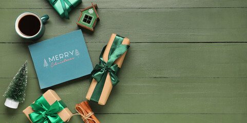 Christmas greeting card, gift boxes and cup of coffee on green wooden background with space for text