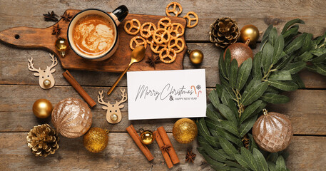 Beautiful Christmas composition with greeting card, decorations and mug of coffee on wooden...