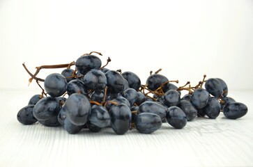 Cluster (bunch, branch) of black grapes on a white background