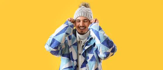 Fotobehang Stylish young man in winter clothes on yellow background © Pixel-Shot