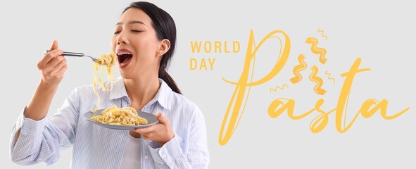 Asian woman eating tasty tagliatelle on light background. World Pasta Day