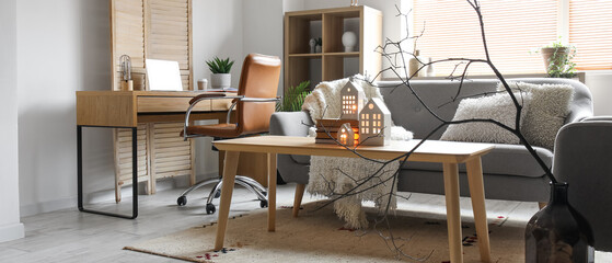 Interior of living room with grey sofa, wooden table and workplace