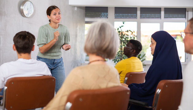 Woman tells an interesting story. Multinational students listening carefully in classroom university