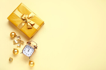 Composition with alarm clock, Christmas gift and decorations on color background