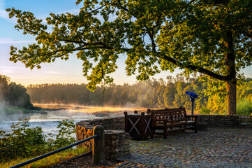 Beautiful park and buildings next to widest waterfall in Europe-Ventas Rumba in Kuldiga, Latvia, during sunrise in autumn