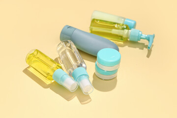 Set of travel cosmetic products on yellow background