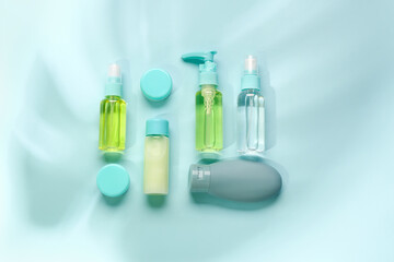 Set of travel cosmetic products on blue background