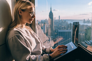 Caucasian female digital nomad keyboarding article for travel blog