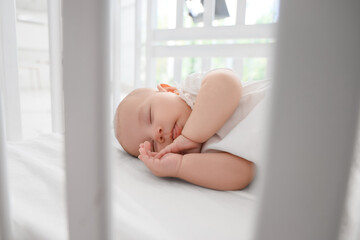 Little cute baby sleeping in crib at home