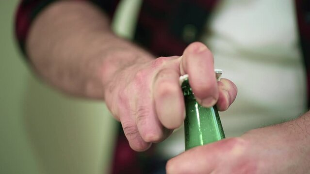 Opening a green glass beer bottle in close-up
