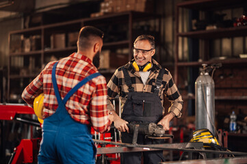 Smiling man talking to his coworker while taking a break from grinding