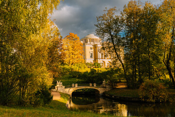 Pavlovsky Palace and Centaur Bridge in autumn in Pavlovsky Park. Colorful autumn foliage and river...