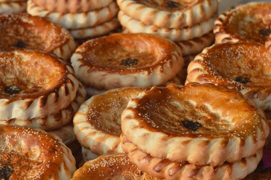 stacked stacks of Asian flour flatbreads sprinkled with cumin. Uzbek national traditional food that is eaten in every home. the entire frame is filled with bread. 