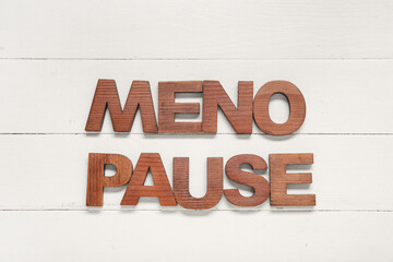 Word MENOPAUSE on white wooden background