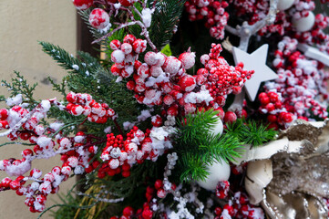 New Year and Christmas decoration with snow-covered spruce branches and red viburnum berries on the street