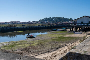 Beach houses in Arcachon Bay with many fisherman's boats and oysters farms, Cap Ferret peninsula,...