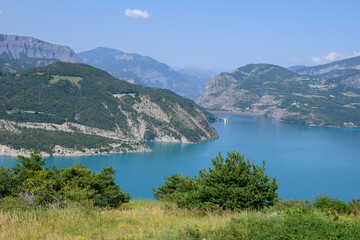 Fototapeta na wymiar View on blue Lake of Serre-Poncon, reservoir border between Hautes-Alpes and Alpes-de-Haute Provence  departments, one of largest in Western Europe