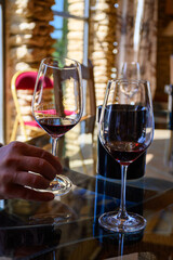 Tasting of red dry wine in Chateauneuf-du-Pape wine making village in France with green vineyards on large pebbles galets and sandstone clay soil
