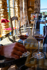 Tasting of red dry wine in Chateauneuf-du-Pape wine making village in France with green vineyards on large pebbles galets and sandstone clay soil
