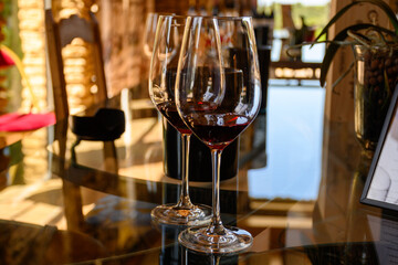 Tasting of red dry wine in Chateauneuf-du-Pape wine making village in France with green vineyards on large pebbles galets and sandstone clay soil