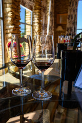 Tasting of red dry wine in Chateauneuf-du-Pape wine making village in France with green vineyards on large pebbles galets and sandstone clay soil