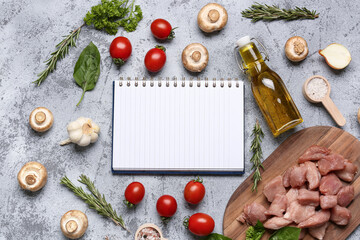 Composition with blank recipe book, raw meat, vegetables and herbs on grunge background