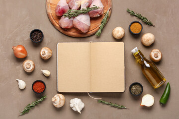 Composition with blank recipe book, chicken legs, vegetables and spices on color background