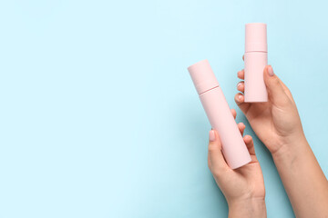 Female hands with cosmetic products on color background, closeup