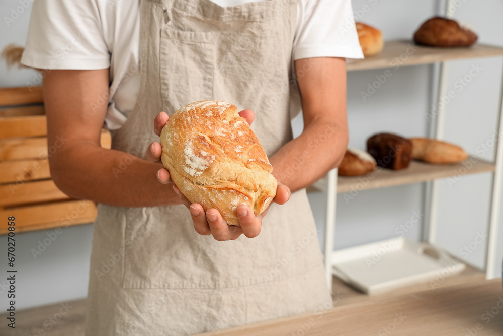 Canvas Prints Handsome young man with loaf of fresh bread in bakery