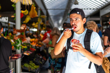 young man is eating fruit - obrazy, fototapety, plakaty