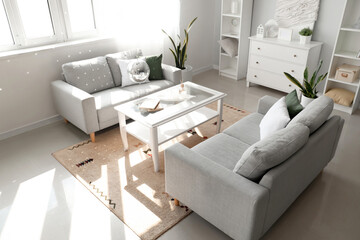 Interior of modern living room with grey sofas, hanging disco ball and coffee table