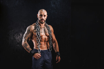 Fototapeta na wymiar Bodybuilder Standing In The Gym With Chains