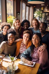 Obraz premium Portrait of group of diverse young people sitting in cafe and smiling