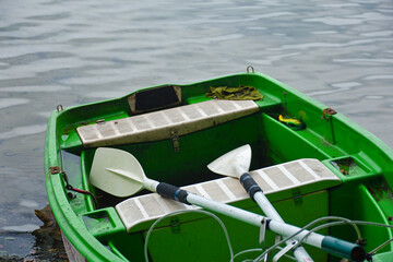 Łódka z wiosłami na jeziorze  - 670275022