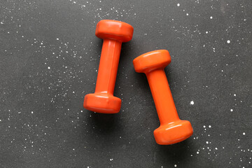 Orange dumbbells on black background