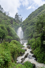 Fototapeta na wymiar A picturesque waterfall in the forests of Ecuador on the outskirts of the city of Otavalo.