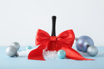 Christmas bell with red bow and balls on blue table