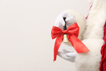 Santa Claus holding Christmas bell with red bow on white background