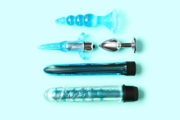 Vibrators and anal plugs from sex shop on blue background
