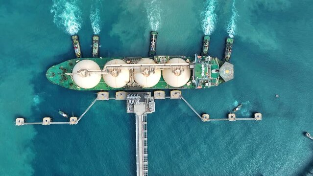 LNG (Liquefied natural gas) tanker anchored in Gas terminal gas tanks for storage. Oil Crude Gas Tanker Ship. LPG at Tanker Bay Petroleum Chemical or Methane freighter export import transportation	
