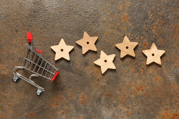 Shopping cart with five stars rating on rusted metal background. Customer experience concept
